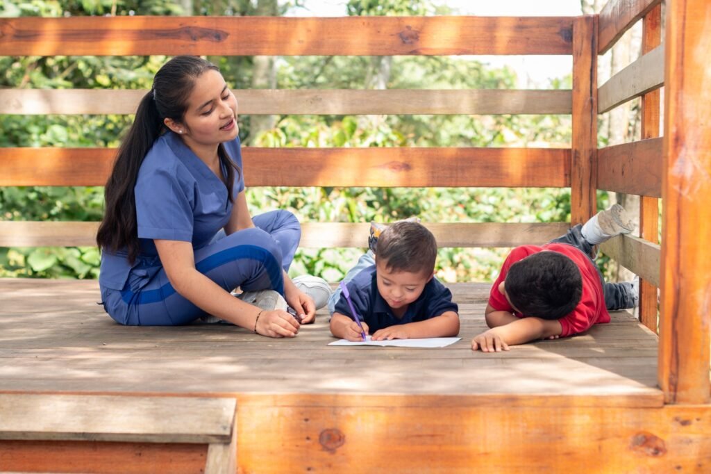 A latin pediatrician works in an occupational therapy session for two children. Children drawing. A latin pediatrician works in an occupational therapy session for two children. Children drawing.